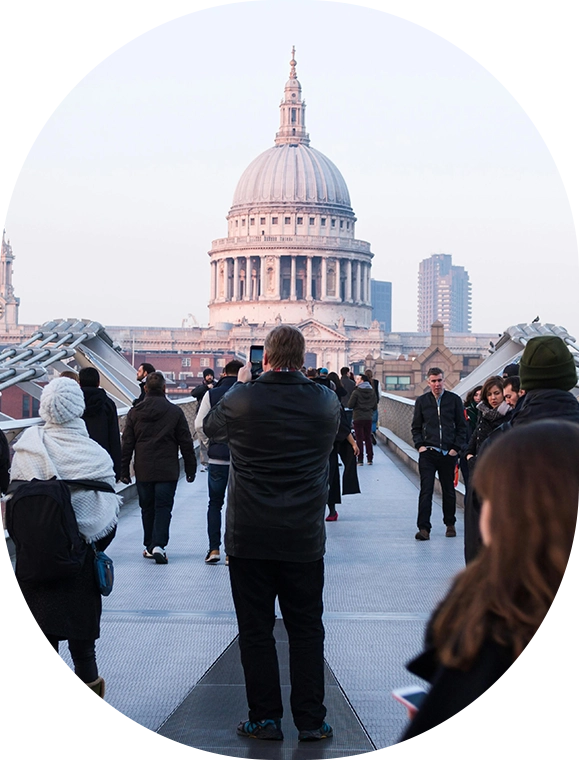 A group of people walking across a bridge.