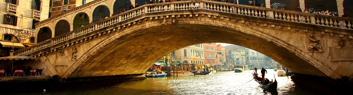 A bridge over the water with boats in it.