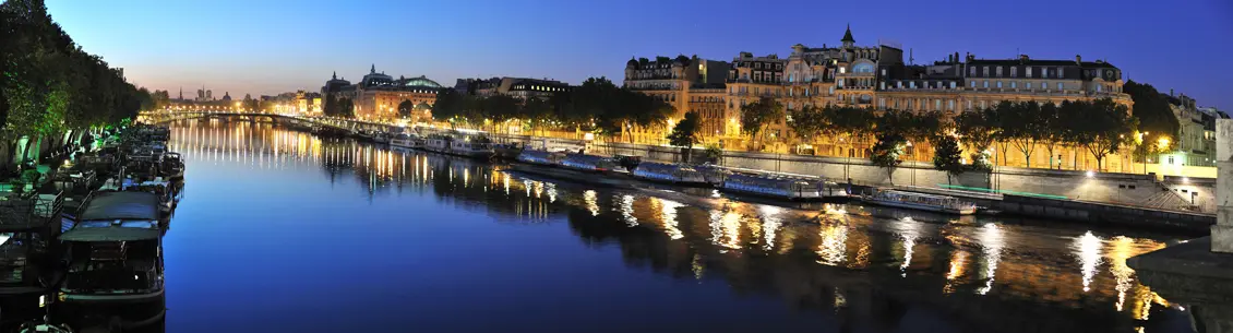 A river with buildings lit up at night.