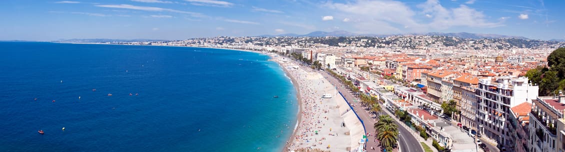 A beach with people swimming and walking on it.