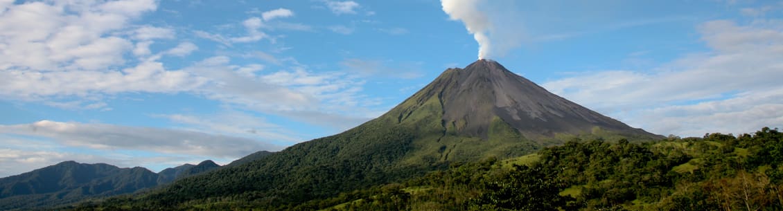 A large mountain with smoke coming from it.