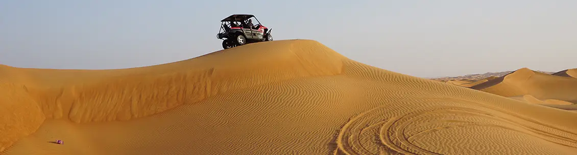 A person riding on top of a dune buggy.