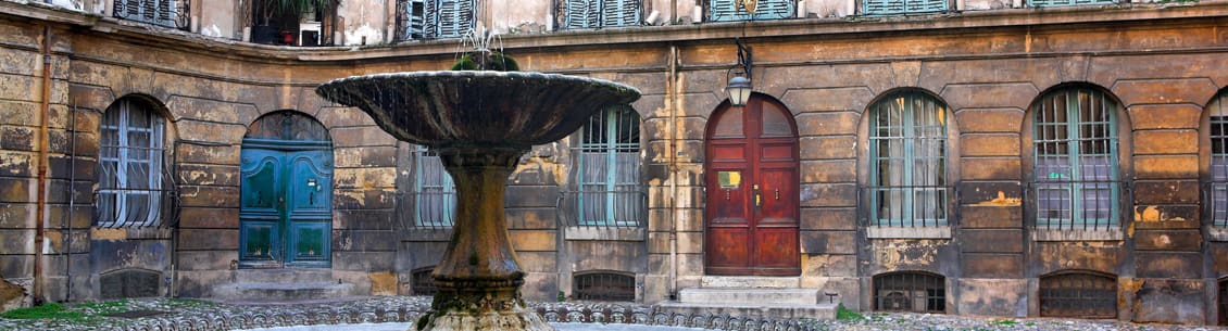 Stone courtyard fountain with old doors.