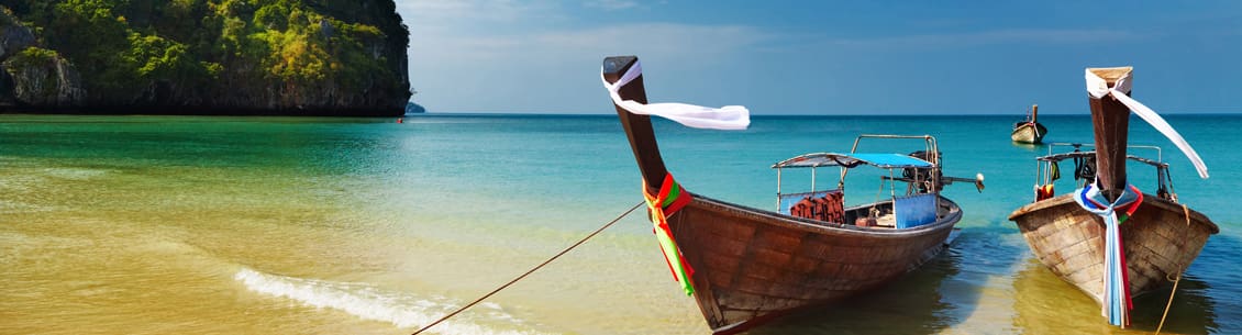 Tropical beach scene with longtail boats.